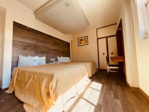 a bedroom with a large bed with a wooden headboard at Hotel Mina in Mexico City