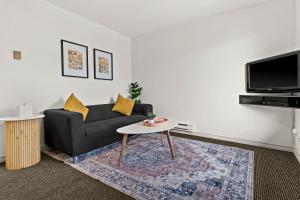 a living room with a couch and a table at Lakeside Villa & Nordic Spa in Penticton