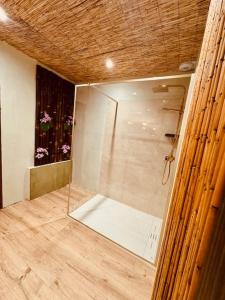 a glass shower in a bathroom with flowers in a window at Nature, évasion, jacuzzi, grande piscine et cinéma in Houdancourt +33 photos