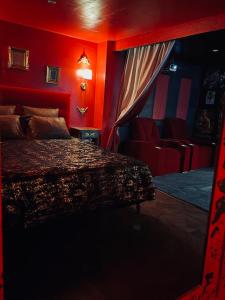 a bedroom with red walls and a bed in it at Nature, évasion, jacuzzi, grande piscine et cinéma in Houdancourt
