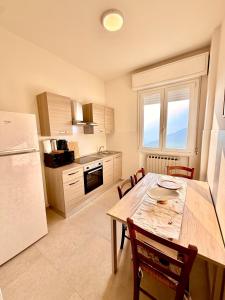a kitchen with a wooden table and a refrigerator at B&B Il COTOGNO - Cucina e Parcheggio Privato in Serramazzoni