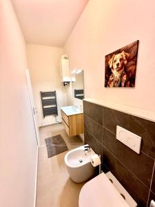 a bathroom with a dog painting on the wall at B&B Il COTOGNO - Cucina e Parcheggio Privato in Serramazzoni
