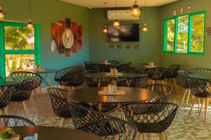 a restaurant with tables and chairs in a room with green walls at Village Resort All Fun Inclusive in Jaboticatubas