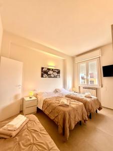 a bedroom with two beds and a tv at B&B Il COTOGNO - Cucina e Parcheggio Privato in Serramazzoni