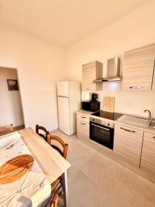 a kitchen with a table and a kitchen with a refrigerator at B&B Il COTOGNO - Cucina e Parcheggio Privato in Serramazzoni +7 photos