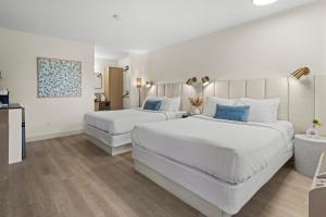 a hotel room with two beds and a table at Lakeside Villa & Nordic Spa in Penticton