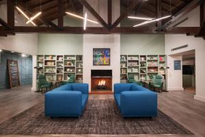a lobby with blue chairs and a fireplace at Holiday Inn Birmingham Bromsgrove by IHG in Bromsgrove