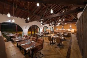 a restaurant with wooden tables and chairs in a room at Holiday Inn Birmingham Bromsgrove by IHG in Bromsgrove