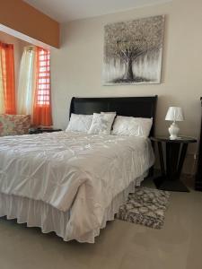 a bedroom with a large bed with a tree painting on the wall at Zoë Oasis - #1 Couple's Choice & Wholesome Getaway in Lilliendahl