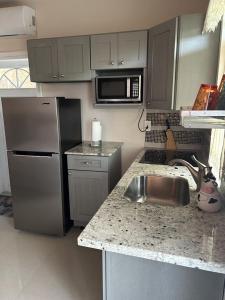 a kitchen with a stainless steel refrigerator and a sink at Zoë Oasis - #1 Couple's Choice & Wholesome Getaway in Lilliendahl +6 photos