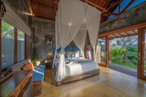 a bedroom with a bed in a room with windows at The Asiki Sebatu in Tegalalang