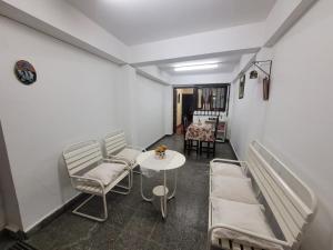 a room with two beds and a table and chairs at Tia Clara in San Salvador de Jujuy