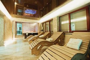 a row of wooden benches in a room at Old Continent Hotel in Uzhhorod