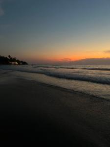 a sunset on the beach with the ocean at Casa Esmeralda in La Huerta