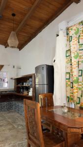 a kitchen with a wooden table and a refrigerator at Casa Esmeralda in La Huerta