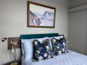 a bedroom with a bed with pillows and a picture on the wall at MacDonald Arms Hotel in Tobermory