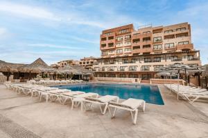 a hotel with a swimming pool with lounge chairs and a building at Marinaterra Hotel & Spa in San Carlos