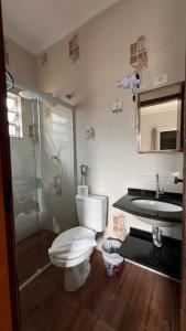 a bathroom with a toilet and a shower and a sink at Pousada Mar de Ubatuba - Itaguá in Ubatuba +39 photos