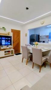 a dining room with a table and chairs and a tv at Apartamento paid'egua completo em Belém in Belém