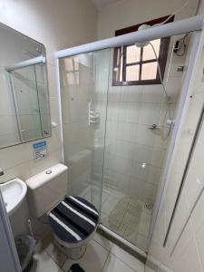 a bathroom with a toilet and a glass shower at Hostel Arraial in Arraial do Cabo +18 photos