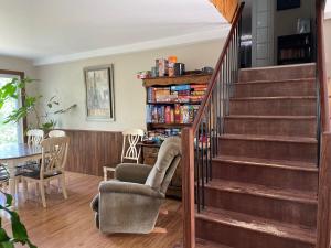 a living room with a staircase and a chair at 5 bedroom Waterfront house in Tracadie