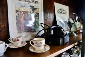 a tea kettle and two cups on a shelf at Rumah Hadeka sawan in Sawan +18 photos