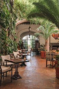 a restaurant with tables and chairs and plants at Casa de Sierra Nevada, A Belmond Hotel, San Miguel de Allende in San Miguel de Allende