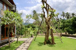 a swing in a garden next to a building at Rumah Hadeka sawan in Sawan