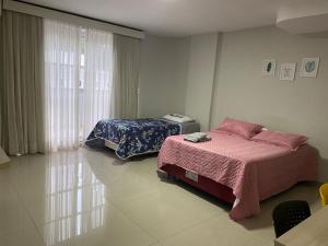 a bedroom with two beds and a window at 101 - Saint Sebastian Flat in Jaraguá do Sul