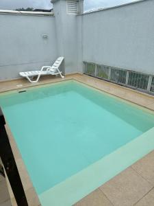 an empty swimming pool with a chair and a lawn chair at 101 - Saint Sebastian Flat in Jaraguá do Sul