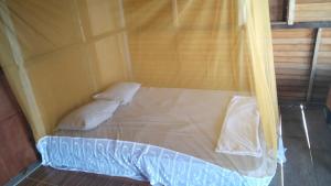 a bed with two pillows in a room at Adefiro homestay in Waisai