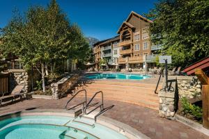 a swimming pool at a resort with a building at Legends Whistler, by Lodging Ovations in Whistler
