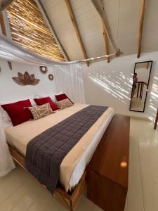 a bedroom with a large bed with red pillows at Leeloo Boutique Hotel in Las Terrenas