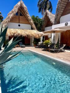a villa with a swimming pool and a house at Leeloo Boutique Hotel in Las Terrenas