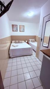 a bedroom with two beds and a tiled floor at Pousada Farol do Porto Nova ADM 2026 in Porto De Galinhas +17 photos