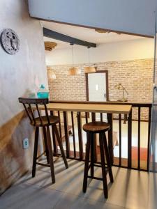 a wooden table and two stools in a room at Palmares, Casa Rustica Suites Buzios in Búzios