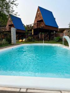 a large swimming pool in front of a house at Posada Turística Alpinas Kamba in Paraguarí
