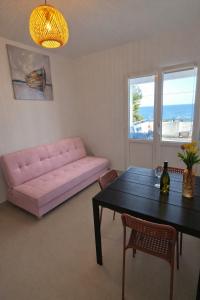 a living room with a pink couch and a table at Apartments by the sea Zavalatica, Korcula - 247 in Zavalatica