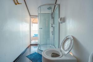a bathroom with a glass shower and a toilet at Uros Titicaca Kurmi lodge in Puno
