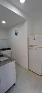 a white kitchen with a refrigerator and a stove at Portales del Vino 2 in Tupungato