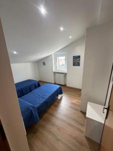 ein Schlafzimmer mit zwei blauen Betten und einem Fenster in der Unterkunft Casa Piaggiola in Gubbio