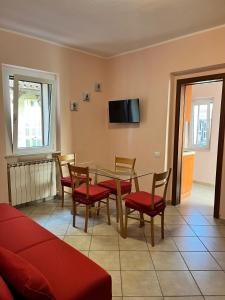 ein Wohnzimmer mit Tisch, Stühlen und Fernseher in der Unterkunft Casa Piaggiola in Gubbio