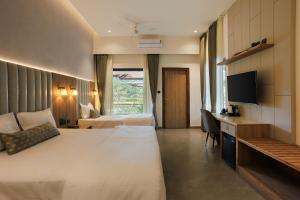 a hotel room with a bed and a desk at Kohu By Honeyvale in Mudigere