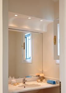 ein Badezimmer mit einem Waschbecken und einem großen Spiegel in der Unterkunft Villa Irini in Porto Heli