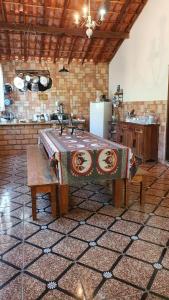 a kitchen with a table with a blanket on it at Camping e Pouso Recanto das Flores in Tiradentes +37 photos