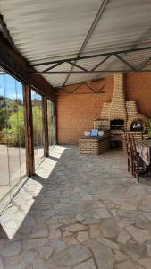 a large patio with a fireplace in a building at Camping e Pouso Recanto das Flores in Tiradentes