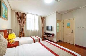 a hotel room with two beds and a television at 古城青年旅舍 in Xi'an