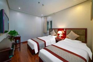 a hotel room with two beds and a table with a lamp at 古城青年旅舍 in Xi'an