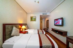 a hotel room with two beds and a flat screen tv at 古城青年旅舍 in Xi'an