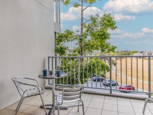 a balcony with a table and chairs and a view of a street at Salt Beach Resort Apartments by Kingscliff Accommodation in Kingscliff
